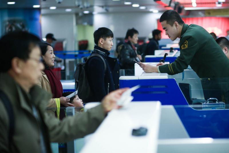 图:青岛机场边检站民警为旅客办理通关手续/资料图片