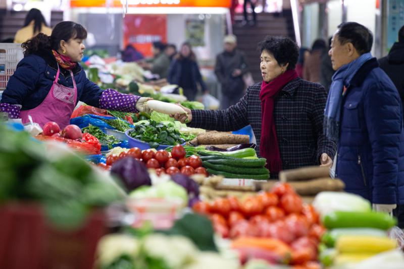 图:9日,市民在江苏省南京市的一家农贸市场买菜\新华 