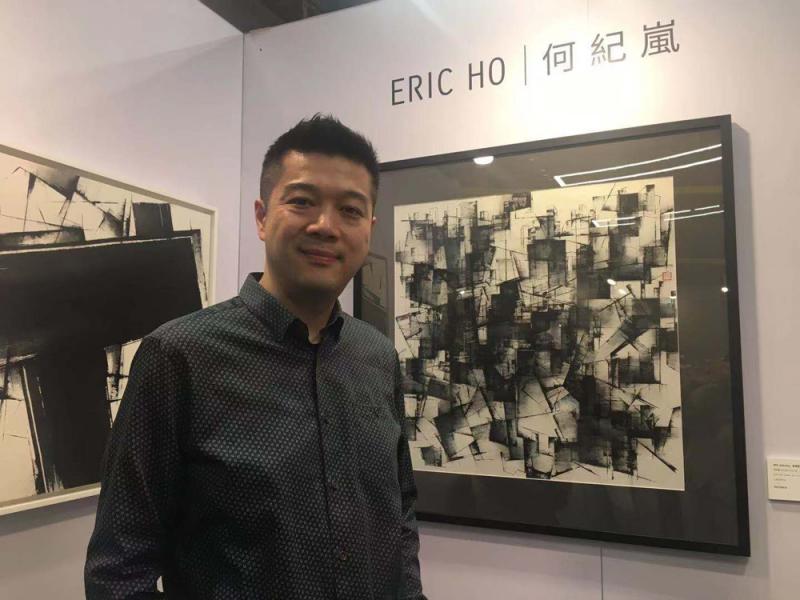 图:香港水墨画家何纪岚,其旁作品为《香港格式—光影/大公报记者