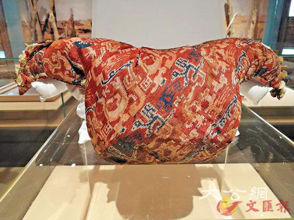■「營盤美男」出土時枕着的絲綢縫製「雞鳴枕」，這一寓意「重生」的中原葬俗在一些偏遠農村還保留着。
