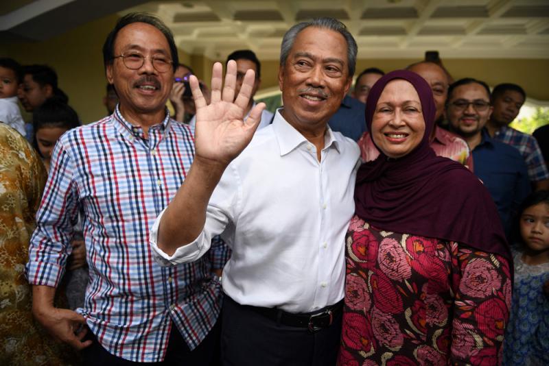 图:马来西亚新总理毛希丁(中)2月29日与家人在寓所门口接受採访\法新