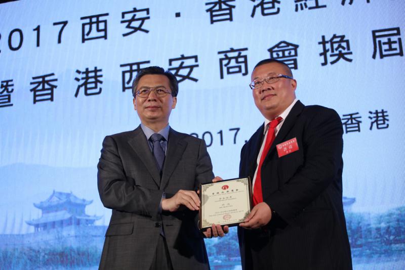 图:西安市委书记王永康(左)为新任香港西安商会会长许亮颁发聘书
