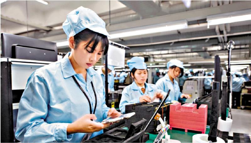 图为东莞某手机工厂,一名女工在产线上测试  网络图片